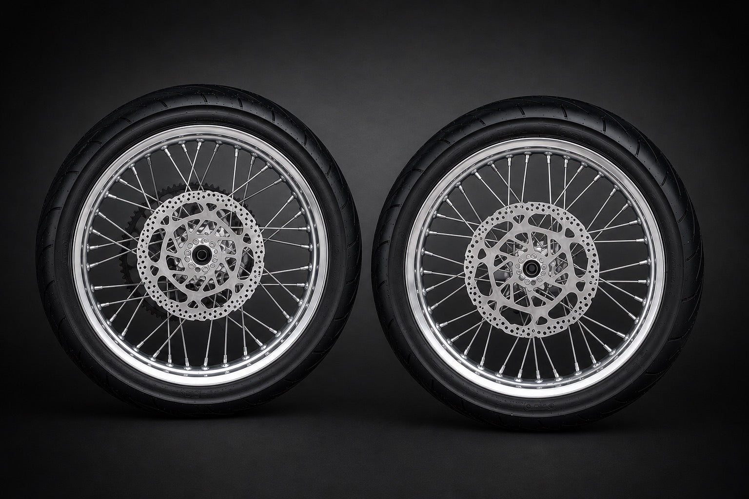 Two chrome e-moto wheels side by side in a dark studio